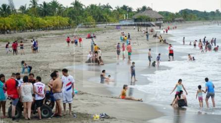 Turistas disfrutando entre familia y amigos ayer domingo en las playas de Tela.
