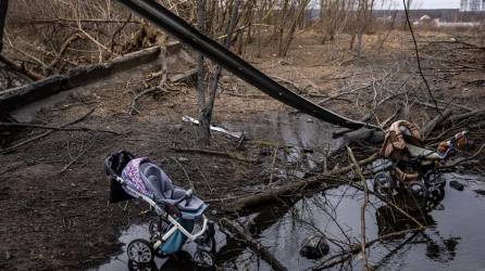 Los cochecitos abandonados se muestran debajo de un puente destruido mientras la gente cruzaba el hormigón derrumbado para huir de la ciudad de Irpin, suburbio al noroeste de Kiev. .