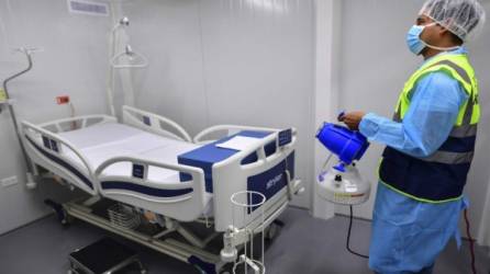 Un empleado rocía desinfectante en una habitación del nuevo Hospital Integrado 'Panamá Solidario' para pacientes gravemente enfermos debido a COVID-19. Foto AFP