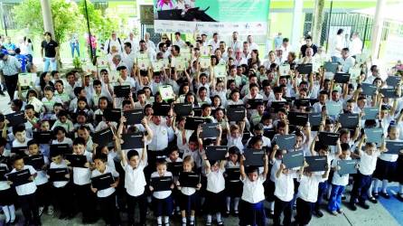 Con una sonrisa recibieron los pequeños estudiantes la computadora entregada por las autoridades. Diferentes autoridades encabezaron la mesa principal durante el acto de entrega. Los niños hicieron presentaciones artísticas. Fotos: Melvin Cubas.