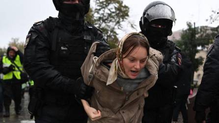 Dos agentes de la policía rusa detienen a una mujer protestante. Según OVD-Info, una organización especializada en el recuento de arrestos, al menos “707 personas ya fueron detenidas en 32 ciudades” de toda Rusia; más de la mitad, en Moscú.