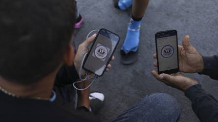 Migrantes navegan por la aplicación móvil CBP One en busca de una cita para ingresar a los Estados Unidos.