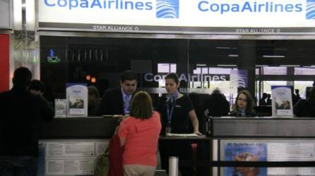 Tres empleados de Copa Airlines atienden a dos pasajeros en el aeropuerto Ramón Villeda Morales. Foto: Cristina Santos