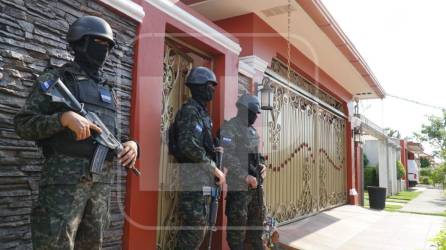 Policías militares custodian la vivienda allanada en Costa Verde en San Pedro Sula.