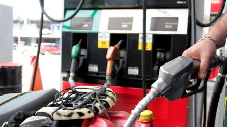 Bombero de gasolinera en Honduras rellenando un recipiente | Fotografía de archivo