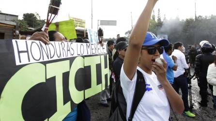Una hondureña al frente de una pancarta alusiva a la Cicih.