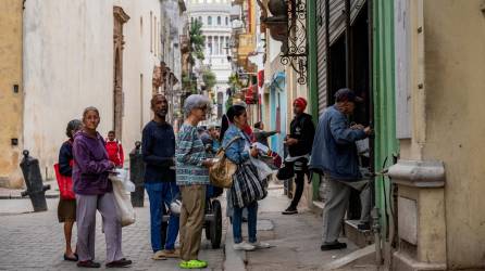 Un grupo de personas hace fila en una panadería en La Habana.