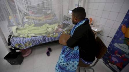 Un familiar aguarda en la sala donde son tratados pacientes con dengue en el Hospital Escuela Universitario de Tegucigalpa. Fotos: EFE