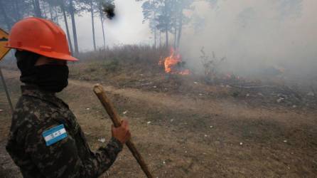 Un militares trabaja en apagar un incendio forestal.