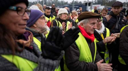 Miembros del movimiento 'chaleco amarillo' (gilets jaunes) aplauden durante una manifestación en homenaje a Chantal Mazet, un año después de la muerte de la mujer de 63 años en una rotonda en Le Pont-de-Beauvoisin.