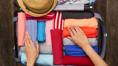 Escoge solo ropa que realmente necesitarás y dóblala en rollitos, así tendrás más espacio para todas tus prendas.