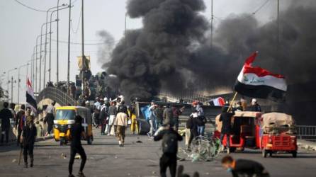 Iraqi protesters erect barricades amid clashes with riot police following a demonstration at Baghdad's Tayaran Square, east of Tahrir Square, on January 20, 2020. - Three Iraqi protesters were killed in the capital as thousands of anti-government demonstrators sought to shut streets across the country today, their deadline for authorities to implement long-awaited reforms. (Photo by AHMAD AL-RUBAYE / AFP)