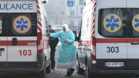 Un trabajador médico fuma entre ambulancias durante la llegada de los evacuados de China, golpeado por el coronavirus, en un aeropuerto de Kharkiv el 20 de febrero de 2020. El jueves, un avión que transportaba a 45 ucranianos y 27 extranjeros de la ciudad china de Wuhan, el epicentro de la muerte. brote de coronavirus, llegó a la ciudad oriental ucraniana de Járkov. / AFP.