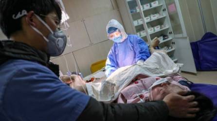 TOPSHOT - In this photograph taken on February 22, 2020 a pregnant woman wearing a protective facemask gives birth at a hospital in Wuhan in China's central Hubei province. - A group of volunteers in Wuhan works on helping pregnant women to go to hospitals in the quarantined city during the COVID-19 coronavirus outbreak. (Photo by STR / AFP) / China OUT