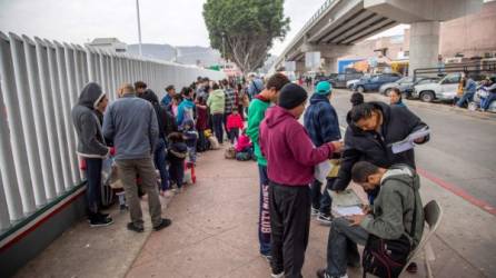 Un grupo de migrantes venezolanos, guatemaltecos, hondureños y mexicanos esperan para iniciar la solicitud de visa humanitaria afuera de la oficina fronteriza estadounidense de El Chaparral, en la frontera de la ciudad de Tijuana. EFE