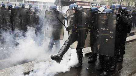 Paris (France), 01/05/2023.- A riot police kicks a tear gas canister during clashes at the annual May Day march in Paris, France, 01 May 2023. Despite the Constitutional Council's adoption of the law on 14 April raising the retirement age in France from 62 to 64 years old, protests against pension reform are being held in France on this International Workers' Day. Following the filing of a new appeal by the left-wing senators, a new decision is expected on 03 May. (Protestas, Francia) EFE/EPA/CHRISTOPHE PETIT TESSON