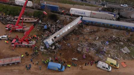 This aerial drone photograph taken on March 1, 2023, shows emergency crews examining the wreckage after a train accident in the Tempi Valley near Larissa, Greece. - At least 32 people were killed and another 85 injured after a collision between two trains caused a derailment near the Greek city of Larissa late at night on February 28, 2023, authorities said. A fire services spokesman confirmed that three carriages skipped the tracks just before midnight after the trains -- one for freight and the other carrying 350 passengers –- collided about halfway along the route between Athens and Thessaloniki. (Photo by STRINGER / AFP)