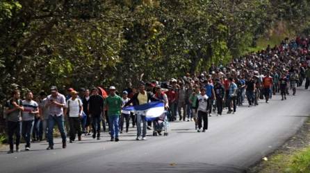 Honduran migrants walk with a Honduran flag near Esquipulas, Chiquimula departament, Guatemala, on January 16, 2020, after crossing the border in Agua Caliente from Honduras on their way to the US. - Hundreds of people in the vanguard of a new migrant caravan from Honduras forced their way across the border with Guatemala on Wednesday, intent on reaching the United States. (Photo by Johan ORDONEZ / AFP)