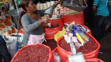 Consumo. Una vendedora pesa una media de frijoles. El grano pertenece a la primera línea de alimentos.