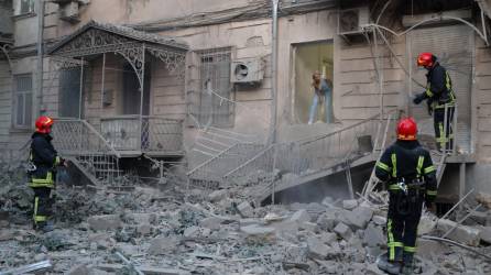 Rescatistas ucranianos inspeccionan un vecindario bombardeado en Odesa.