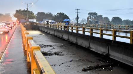 Pobladores observan hoy el aumento del caudal del río Chamelecón por causa de la tormenta tropical Julia, en La Lima, Cortés (Honduras).
