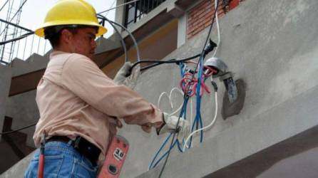 Un técnico reconecta la energía a un hogar al que se le suspendió el servicio eléctrico.