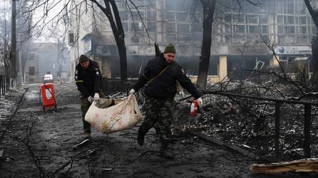 Rescatistas retiran el cuerpo de un civil fallecido durante uno de los bombardeos a la capital ucraniana.