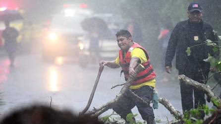 Cuerpos de rescate y socorro despejan el camino de acceso al lugar donde cinco soldados murieron por un deslizamiento de tierra tras el paso de la tormenta tropical Julia, en Comasagua, El Salvador.