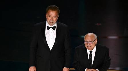 US actor Danny DeVito (R) and Austrian-US actor and former Governor of California Arnold Schwarzenegger present the award for Best Visual Effects onstage during the 96th Annual Academy Awards at the Dolby Theatre in Hollywood, California on March 10, 2024. (Photo by Patrick T. Fallon / AFP)