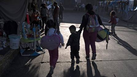Una familia llega a un improvisado campamento de migrantes en Tijuana. EEUU inició hoy a devolver los solicitantes de asilo a México.