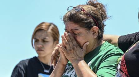 María López llora mientras visita un monumento improvisado en el lugar donde se descubrió el tráiler con migrantes adentro, en las afueras de San Antonio, Texas