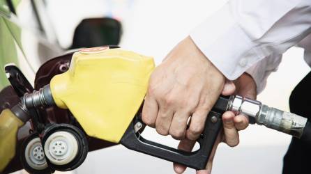 Man putting gasoline fuel into his car in a pump gas station