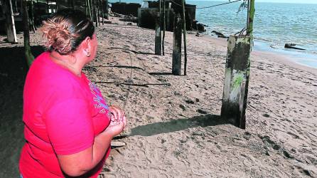 Una mujer mira el mar en la playa de Cedeño. Su casa está hecha de madera y lámina, pues ha perdido su patrimonio varias veces debido a la elevación del mar. Se resiste a irse de la zona.