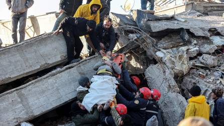 Rescatistas sacan a una persona con vida de entre los escombros de un edificio en Turquía.