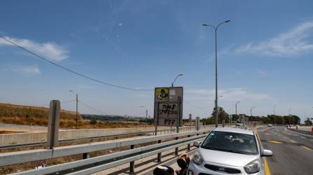 Varias personas se protegen tras el lanzamiento de misiles desde Gaza a Tel Aviv este domingo.