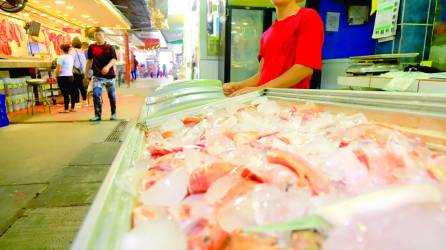 <b>Un joven trabaja en una pescadería del mercado Dandy en San Pedro Sula. Fotos: Melvin Cubas.</b>