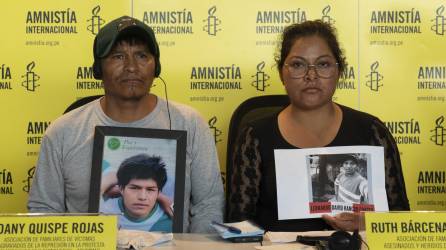 Familiares de dos de las víctimas en las violentas protestas muestran sus fotografías en un evento de Amnistía Internacional en Lima.