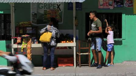 Una mujer compra por una calle de Tegucigalpa, en una fotografía de archivo.