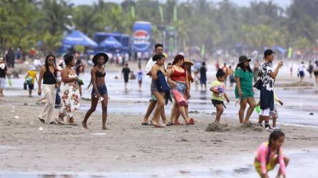 Veraneantes de diferentes partes de Honduras caminan por las playas de Tela bajo un cielo nublado a causa de la masa de aire frío que afecta principalmente Atlántida y Colón.