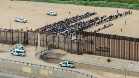 Vista aérea de migrantes agrupados mientras esperan ser procesados en el lado de la frontera de Ciudad Juárez en El Paso, Texas.