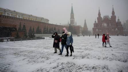 Un grupo de personas visitan la plaza roja de Moscú pese a fuertes nevadas.