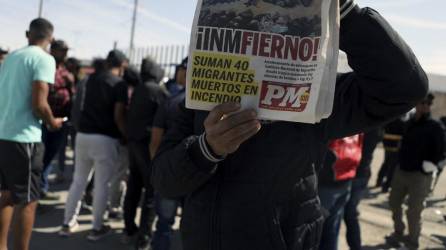 Un migrante muestra un periódico durante una protesta frente a un centro de detención de inmigrantes en Ciudad Juárez.