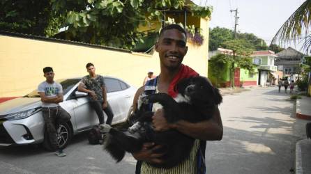 El migrante venezolano Gilberto Rodríguez posa con su perro llamado Negro afuera de la Casa del Migrante en Tecun Uman