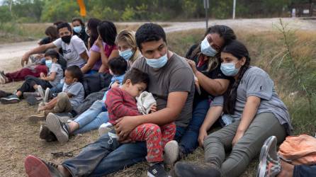 Una familia guatemalteca espera con otros inmigrantes para abordar un autobús de Aduanas y Protección Fronteriza de EE. UU. a un centro de procesamiento después de cruzar la frontera desde México.