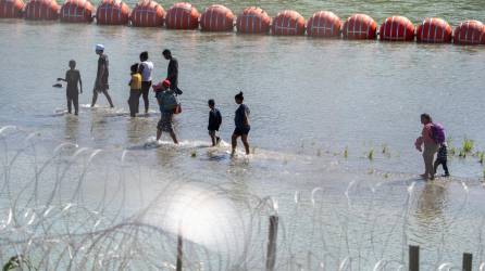 Un grupo de migrantes cruza el Río Bravo pese a la barrera de boyas instaladas por el Gobierno de Abbott.