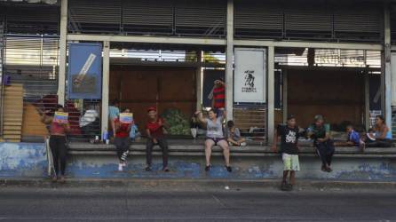 Migrantes permanecen en una estación de transporte público fuera de servicio en Tegucigalpa (Honduras). EFE/Gustavo Amador