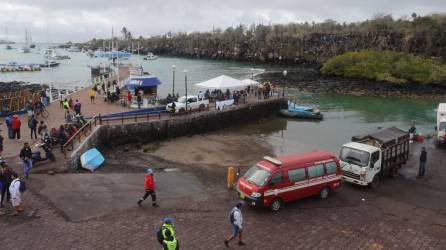 Bomberos y personal de la Marina llegan con un cuerpo recuperado del mar en Puerto Ayora en la Isla Santa Cruz, Islas Galápagos.