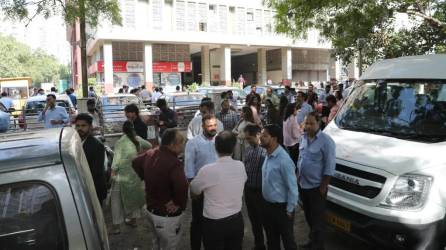 Ciudadanos permanecen fuera de sus oficinas después de que se sintieran temblores en Nueva Delhi, India.
