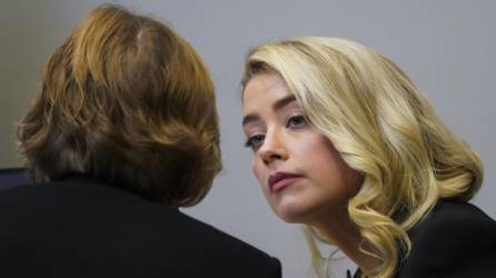 La actriz Amber Heard habla con su abogada Elaine Bredehoft durante el juicio por difamación interpuesto por su exesposo.