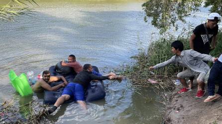 Un grupo de migrantes, ayudados de un inflable, intentan cruzar el Río Bravo en Tamaulipas (México).